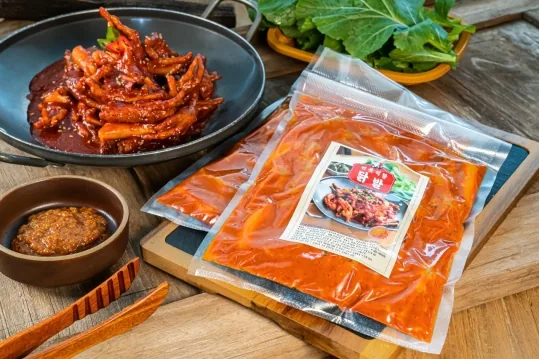 양념 닭발 팬과 "연못식당 닭발" 라벨을 붙인 진공 포장 팩, 막장, 잎채소